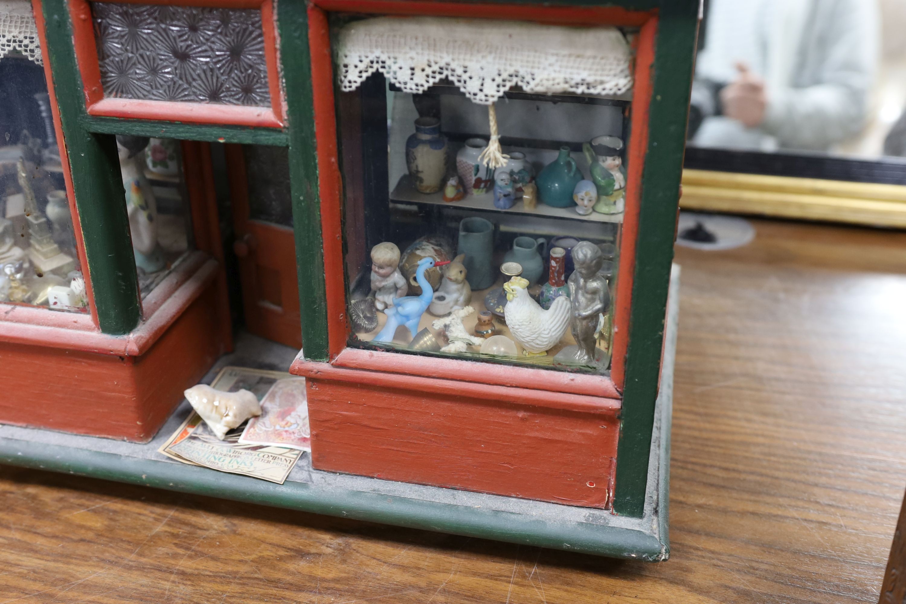 A dolls shop and contents, 43 cms high x 46 cms wide.